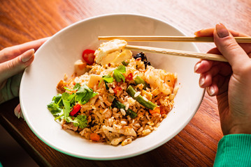 woman eating rice with vegetables