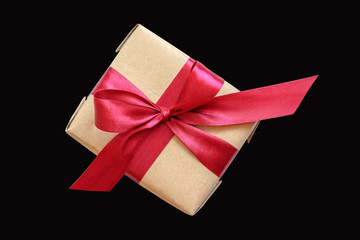 Gift box with red ribbon isolated on black.