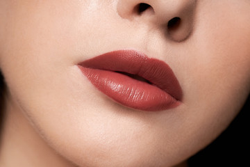 Fototapeta premium Perfect red lips makeup. Close up macro photo with a beautiful female mouth. Full lips full. Large detail of the face. Perfect clear skin, light fresh lip makeup. 