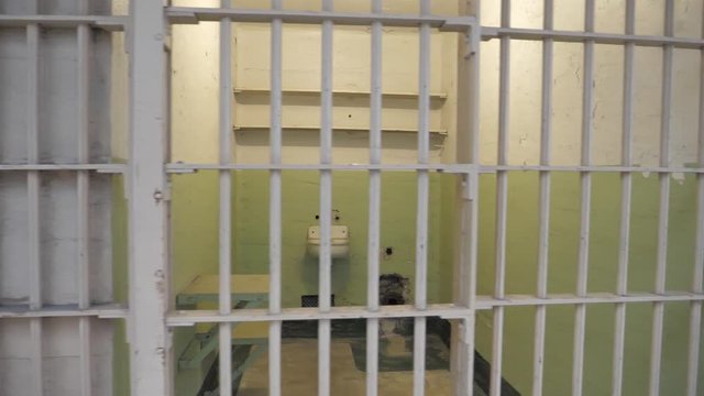 Locked prison jail gaol interior cell with iron bars prisoner incarceration 
