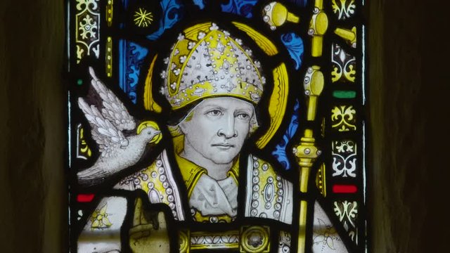 Medium close-up low angle still shot of decorative colourful paintings of Gerald of Wales inside a church, Peak District, Derbyshire, UK