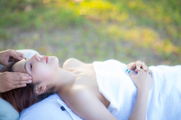 Obraz na płótnie Canvas woman has a facial spa massage in a garden
