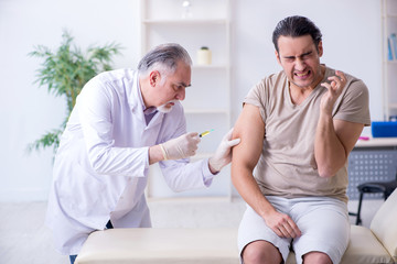 Obraz premium Male patient visitng doctor for shot inoculation