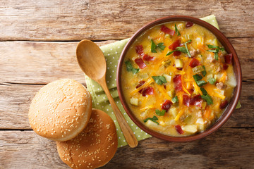 Spicy American cheeseburger soup close-up in a bowl. Horizontal top view