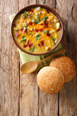 Thick cheeseburger cream soup with vegetables, ground beef, cheese and bacon close-up in a bowl. Vertical top view