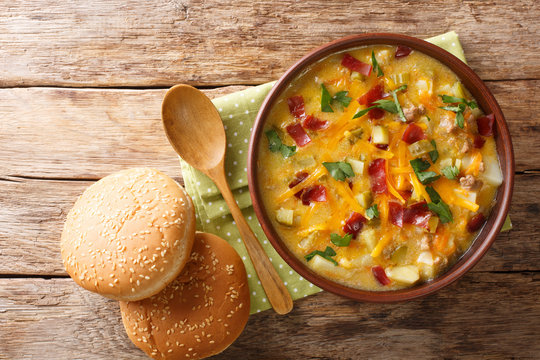 Spicy American cheeseburger soup close-up in a bowl. Horizontal top view
