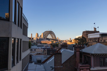 Sydney Harbour Bridge view with building rooftop.