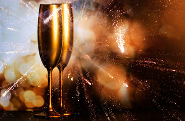 golden champagne glasses and fireworks at new year