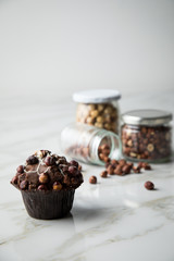 Haselnuss Muffin mit  Walnüssen und Haselnüssen in Vorrat Gläser auf Marmor Tisch hell Hintergrund