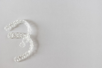 Top view of invisalign braces or invisible retainers on grey background, new orthodontic equipment