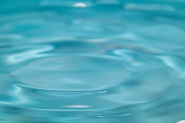 Closeup Water drop falling on the surface of the water and beautiful circular wave ripple, fresh natural mineral water drink water concept