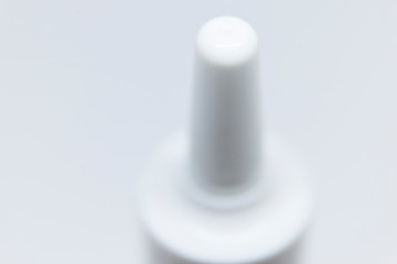top of bottle with nasal spray on white background