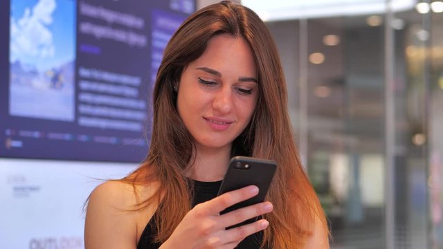 The girl in the mall clicks the phone of a table with a diagram on the background 4k