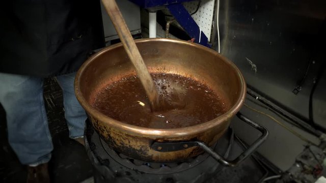 candy making fudge adding butter to sugar simmering in kettle