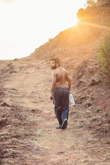 Naklejka premium Young man hiking up a hill road