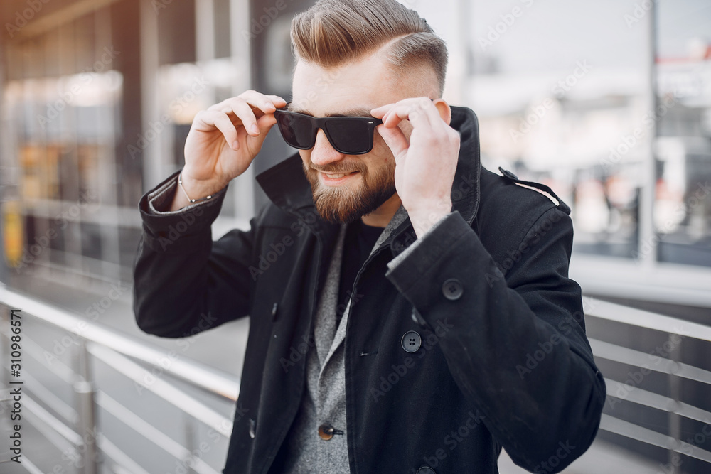 Wall mural man in a stylish suit. businessman in a summer city