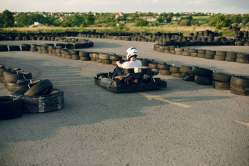 Karting. Man in a white t-shirt. Male with a kart car