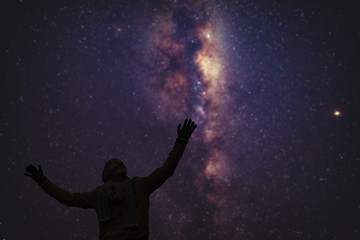 Fototapeta na wymiar Man enjoying starry night with arms wide open.