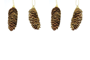 Hanging pattern of four gold coloured fir cones isolated on white background. Greeting card. New Year's holidays.