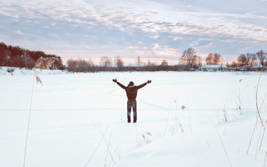 Obraz na płótnie Canvas Traveller With His Arms Raised Enjoys The Winter Landscape