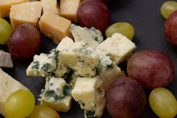 Assorted cheeses on a black plate