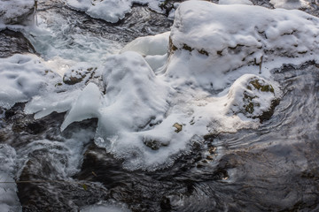 stroemendes wasser ein einem bach mit schnee