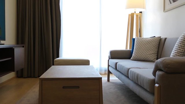 modern livingroom with grey sofa, wood table and wood floor lamp.