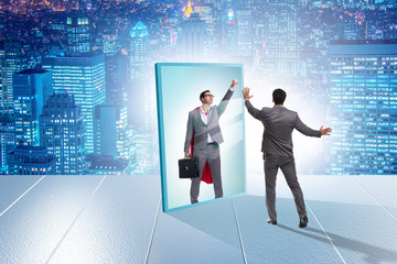 Businessman seeing himself in mirror as superhero