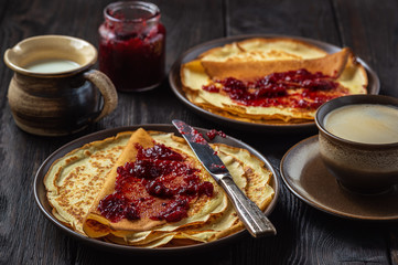 Homemade crepes with berry jam and cup of coffee.
