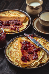 Homemade crepes with berry jam and cup of coffee.
