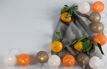 Tangerines with Christmas lanterns on white background with linen napkin. keyboard layout