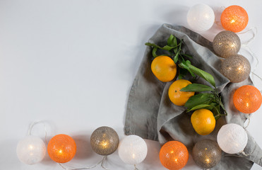Tangerines with Christmas lanterns on white background with linen napkin. keyboard layout