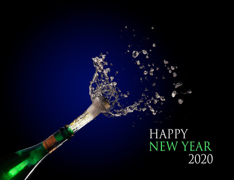 Happy New Year 2020 text and a champagne bottle exploding and shooting out the cork with splashes against a dark blue background, copy space