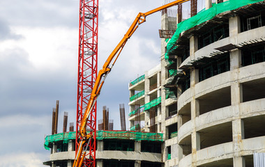 Hoisting crane and Construction crane working building construction on bright blue sky.