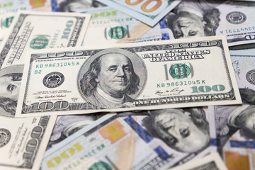 Hundred dollar bills, the foreground and background are blurred.