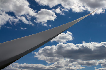 Detail of a large rotor blade of a wind turbine against a cloudy sky in the background