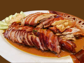Roasted duck and grilled pork isolate on brown background.