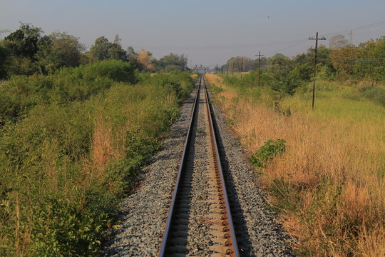railway tracks. one point perspective view of a strait long train rail track. train path in a rural area.