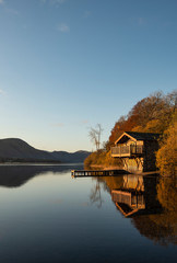 Epic vibrant sunrise Autumn Fall landscape image of Ullswater in Lake District with golden sunlight