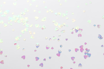 Holographic glitter confetti in heart shape on white background