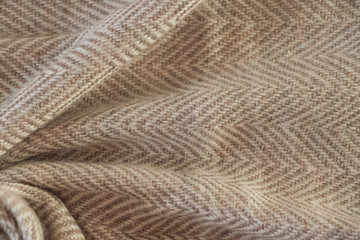 Light beige natural nepalese cashmere fabric. Herringbone tweed, Virgin Wool Background Texture. Expensive material. High resolution. Selective focus. Abstract waving fabric.