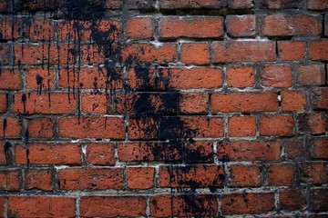 acade of a brick wall. Red brick masonry. Black paint wall