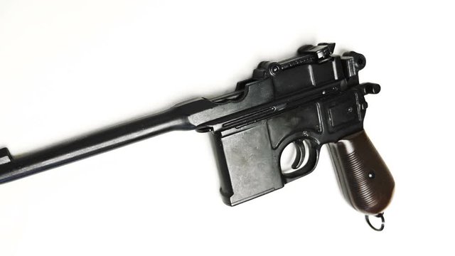 Mauser pistol - a German self-loading pistol, developed in 1895, on a white background. Shot in motion. Macro. Closeup