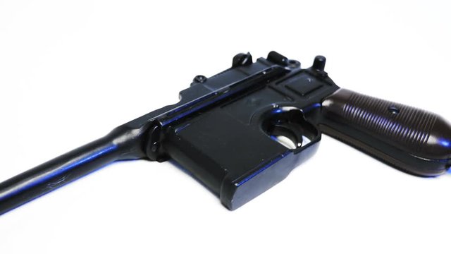 Mauser pistol - a German self-loading pistol, developed in 1895, on a white background. Shot in motion. Macro. Closeup