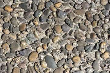 Pebble stone wall texture. Finishing the foundation of the house with stone pebbles