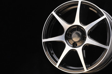 Shiny cast disc with thin sports spokes and polished aluminum surface on a dark background...