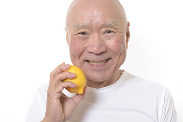 レモンを食べる笑顔のシニア