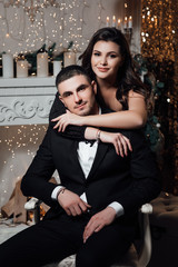 Romantic couple in love feeling happiness about their romance spending christmas eve together, woman and man enjoying perfect relationships and spending winter vacations in cozy home interior