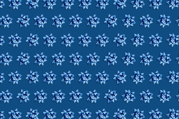 Christmas and new year pattern. Celebration picture. Pink background with blue bright bows. Flat lay, top view, copy space.