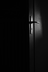 Mondschein beleuchtet leicht die Tür mit Türklinke den dunklen Raum